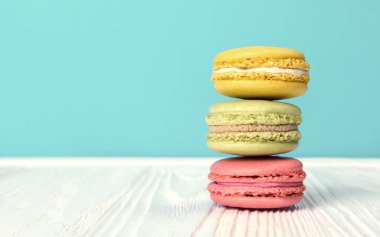 Limon çilek ve fındık lezzet Macarons ahşap masa ve mavi arka plan