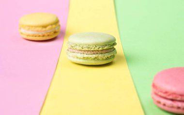 Renkli arka plan üzerinde sarı, yeşil ve pembe macaroons