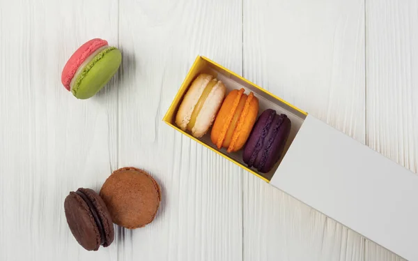 Caixa de macarons francês liso na mesa de madeira — Fotografia de Stock