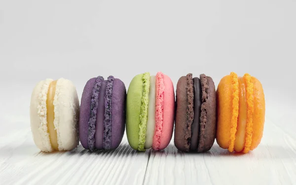 Macaroons franceses coloridos na mesa de madeira branca — Fotografia de Stock