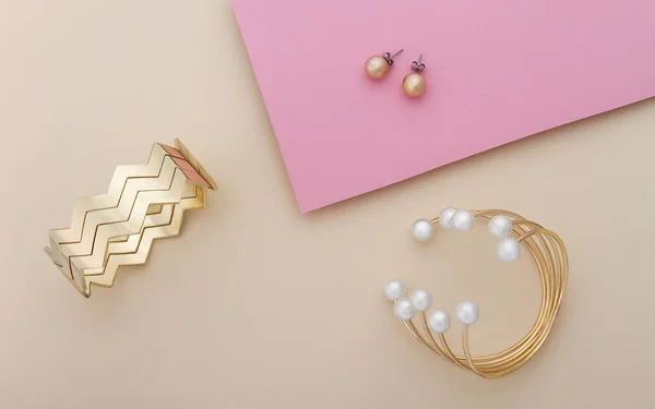 Pulsera de oro y perlas y brazalete de oro con par de pendientes en rosa y beige — Foto de Stock