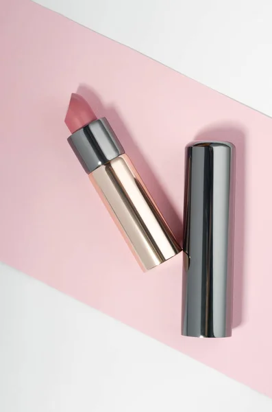 Lápiz labial de color rosa dorado y cromo sobre fondo rosa y blanco — Foto de Stock