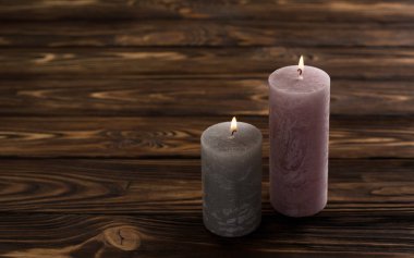 Kahverengi ahşap masa üzerinde iki dekoratif mumlar