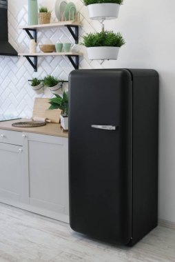 Beyaz ahşap mutfakta siyah retro tasarım buzdolabı