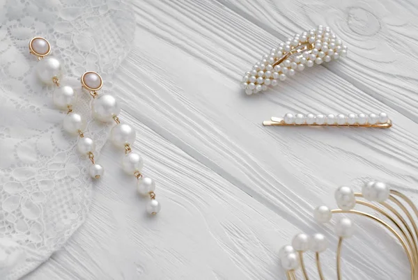 Boucles d'oreilles en or perle, épingles à cheveux et bracelet sur fond blanc — Photo