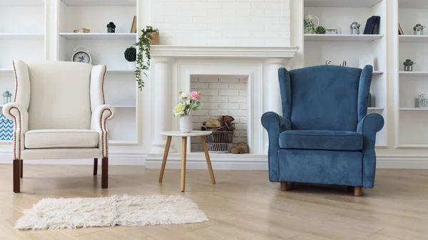 White and blue armchair with white modern table in front of fireplace