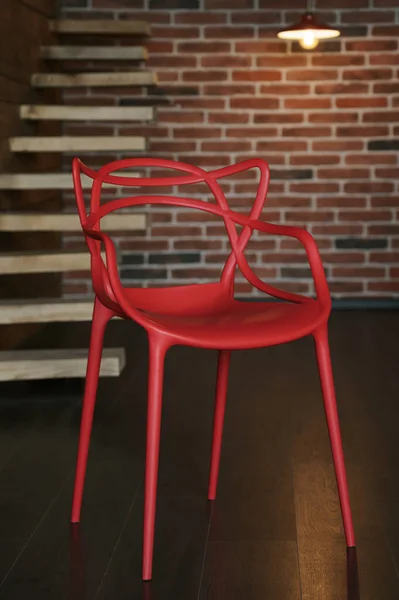 レンガの壁とロフトスタイルの部屋で赤いモダンなデザインのアクリル椅子 — ストック写真