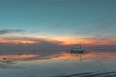 Shore, kırmızı yansımaları su, Sanur, Bali, Endonezya, 21 Nisan 2018 yakın alacakaranlık zaman ayakları ile Endonezya balıkçı teknesi