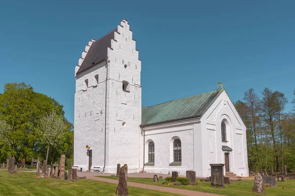 Beyaz bir İskandinav ortaçağ kilise basamaklı gables ve mezar taşları yeşil çim, Finja, İsveç, 9 Mayıs 2018