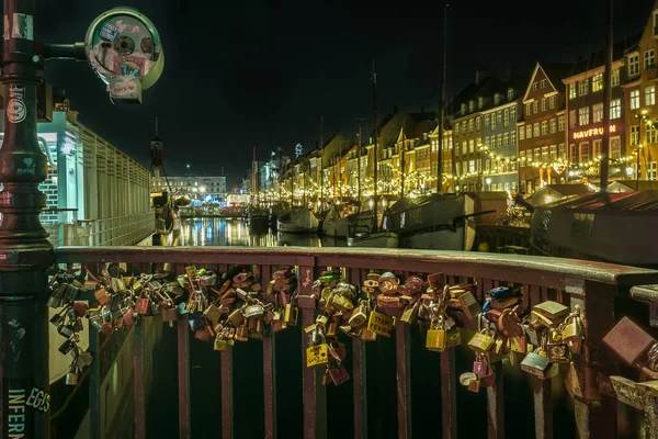 Lovers padlocks fixed to a bridge, Nyhavn at night, Copenhagen, November 23, 2017