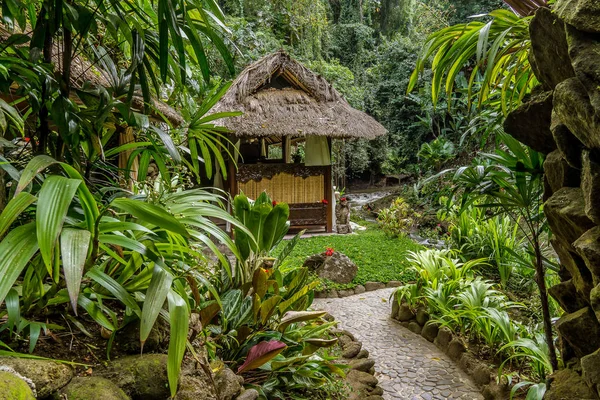 一条稻草覆盖在雨林的丛林小屋在一条小溪的岸边 巴厘岛巴厘岛 2018年4月14日 — 图库照片