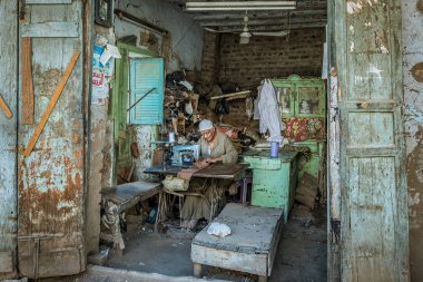 Zavallı bir Mısır terzi bir basit kulübe içinde Esna, Mısır, 27 Ekim 2018 onun eski dikiş makinesi kullanma
