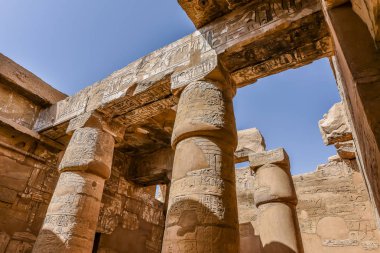22 Ekim 2018 'de Mısır' ın Karnak kentindeki Amon-Re tapınağındaki büyük hipotenüs salonunda sütunlar ve mavi gökyüzü.