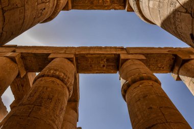 22 Ekim 2018 'de Mısır' ın Karnak kentindeki Amon-Re tapınağındaki büyük hipotenüs salonunda sütunlar ve mavi gökyüzü.