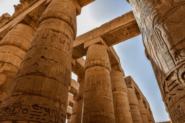 22 Ekim 2018 'de Mısır' ın Karnak kentindeki Amon-Re tapınağındaki büyük hipotenüs salonunda sütunlar ve mavi gökyüzü.