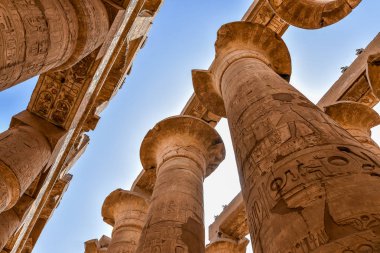 22 Ekim 2018 'de Mısır' ın Karnak kentindeki Amon-Re tapınağındaki büyük hipotenüs salonunda sütunlar ve mavi gökyüzü.