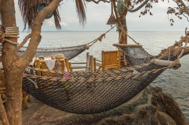 Tayland 'da bir restoranın tepesinde asılı hamaklar ve kadın aksesuarlarıyla dolu bir masa, Haad Son, Koh Pangan, Tayland, 08 Mayıs 2016,