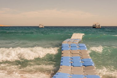 Dalgalar bir yüzen köprü Şarm el Şeyh, Mısır, bir plajda 2 Kasım 2018 hareket ediyor