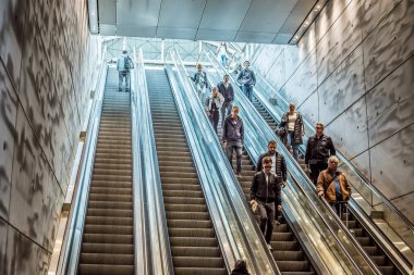 Triangeln tren istasyonunda yürüyen merdivenden inen insanlar.