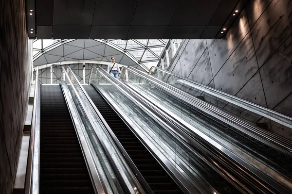 Woman going down the escalator at the railway station Triangeln — Stock Photo, Image