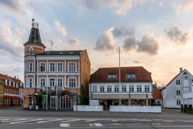S limanında bazı evlerin üzerinde gün batımı ve renkli bulutlar