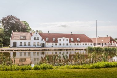Güney Funen, Danimarka'da bir gölet yansıtan eski çiftlik evi