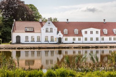 Güney Funen, Danimarka'da bir gölet yansıtan eski çiftlik evi