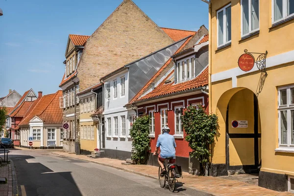 Hombre en bicicleta en una calle pintoresca en Faaborg con casas antiguas — Foto de Stock