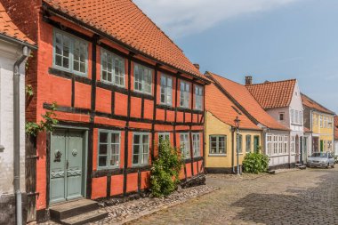 arnavut kaldırımlı bir sokakta kırmızı iki stok yarı ahşap evin cephe