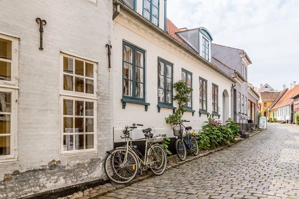 Bicicletas en el pavimento a lo largo de las paredes de casas de piedra en una calle vieja — Foto de Stock