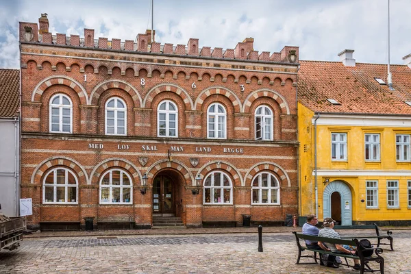 Två män sitter på en bänk framför Stadshuset i Aeroskobing — Stockfoto