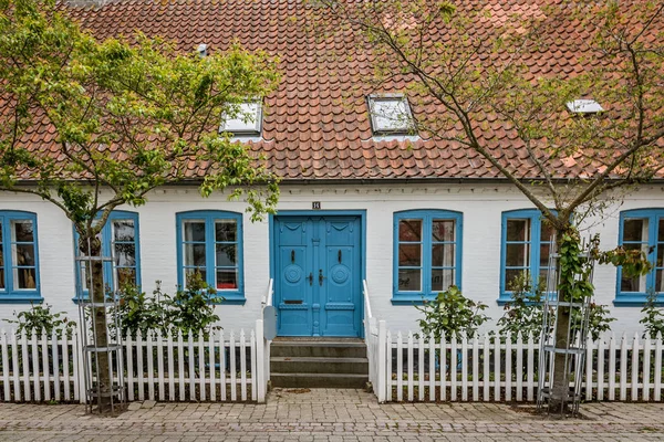 Velha casa dinamarquesa com janelas azuis e uma cerca branca na ilha — Fotografia de Stock