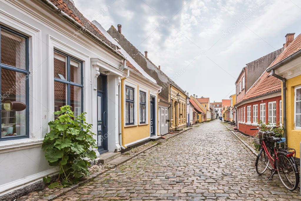 A red bike standing alone in an cobblestone street with romantic