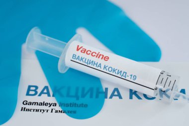 Rus Kiril alfabesiyle aşılanmış şırınga ve arka planda mavi eldivenler, Danimarka, 1 Ağustos 2020