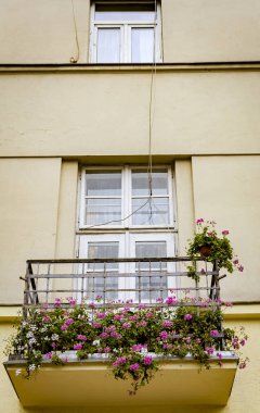 Eski balkon kırmızı çiçekler ile dekore edilmiştir.