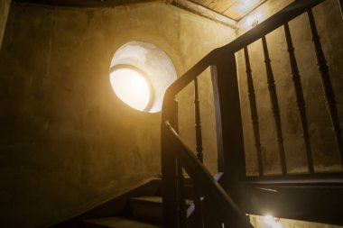 Bir ahşap merdiven ve yuvarlak bir pencere ile eski merdiven