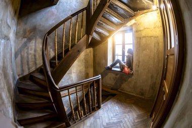 Kız oturarak kız eski girişinde eski entrancethe penceresinde cam kenarında oturan