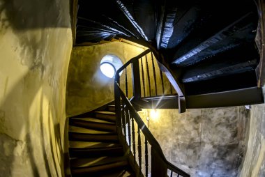 Bir ahşap merdiven ve yuvarlak bir pencere ile eski merdiven