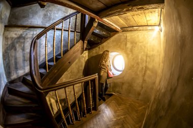 Kız eski giriş yuvarlak pencere tarafından duruyor