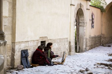 Lviv, Ukrayna-20 Eylül 2016: Iki kız Lviv eski mimarisi arasında bir resim çizmek