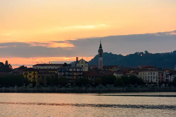 Este meg a várost, a tótól. Sziluettjét a város, a naplemente. Olaszország, Arona. Alakformálás — Stock Fotó