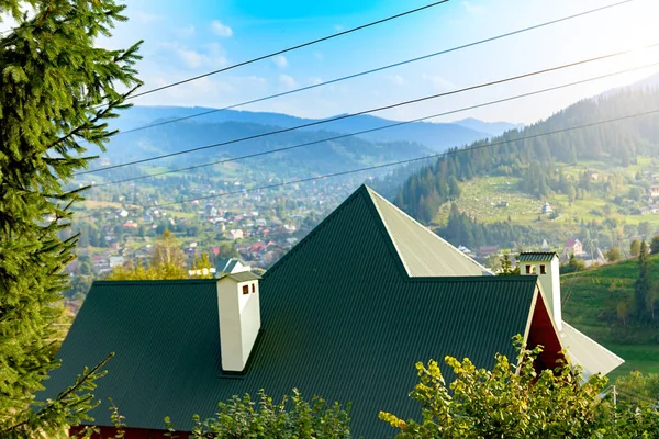 Зеленая крыша дома на фоне горы — стоковое фото