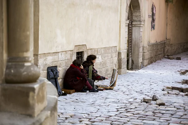 Lviv, Ukrayna-20 Eylül 2016: Iki kız Lviv eski mimarisi arasında bir resim çizmek