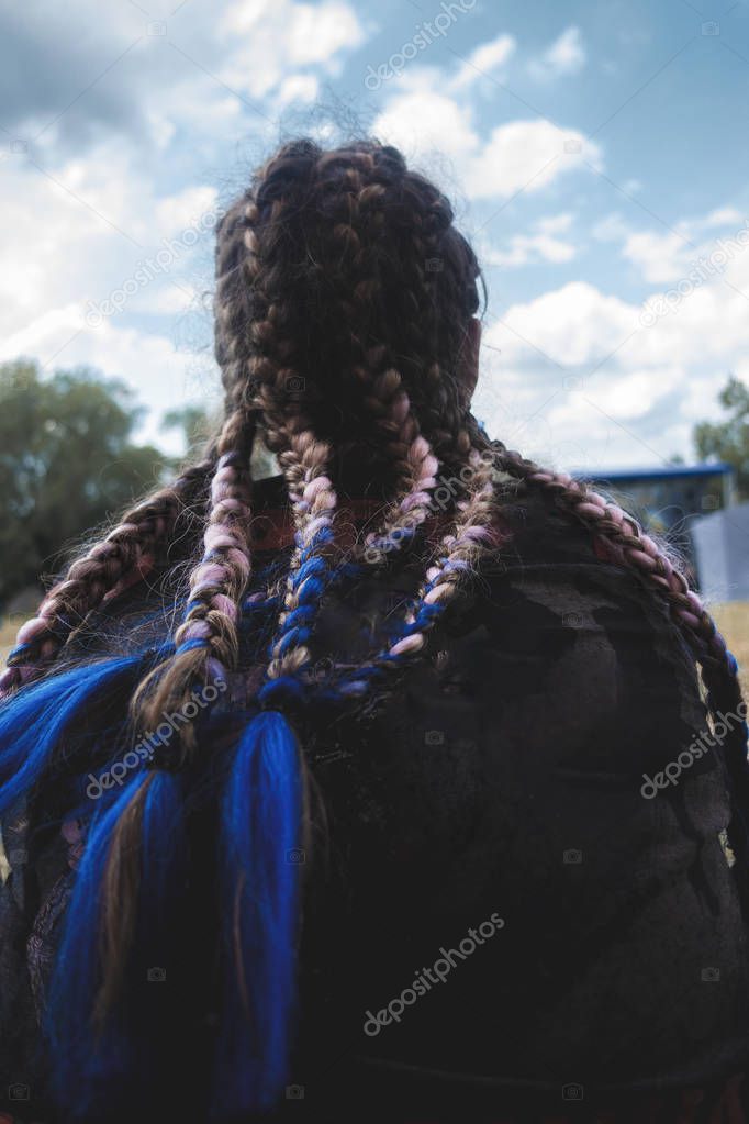 Girl with plaited braids against the sky