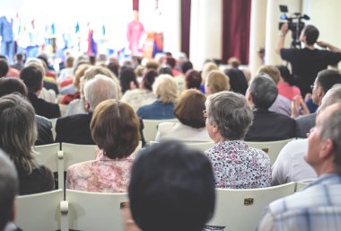 İnsanlar konserde oturuyor..