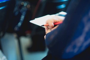 Bir adam bir konferansta kalem tutar.