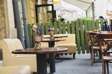 Bir açık hava kafenin masalarında çiçekler