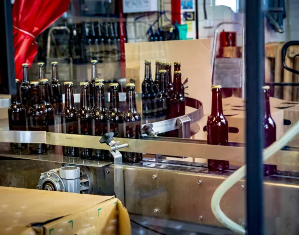 Volledige bier glazen flessen op een transportband regel verplaatsen — Stockfoto