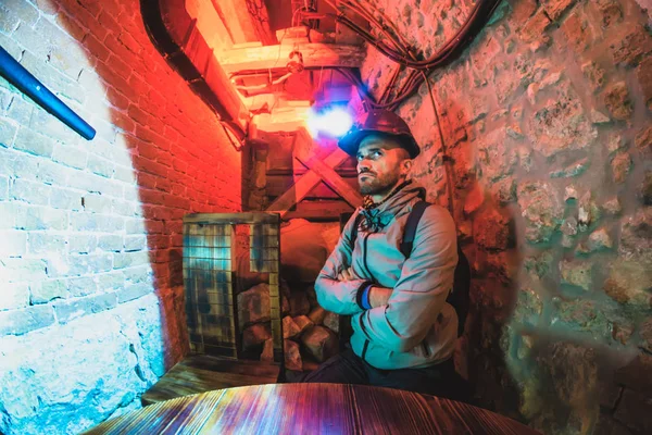 A man in a miner's helmet in a dungeon — Stock Photo, Image