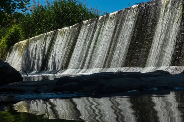 Water falls down along the dam — Stock Photo, Image